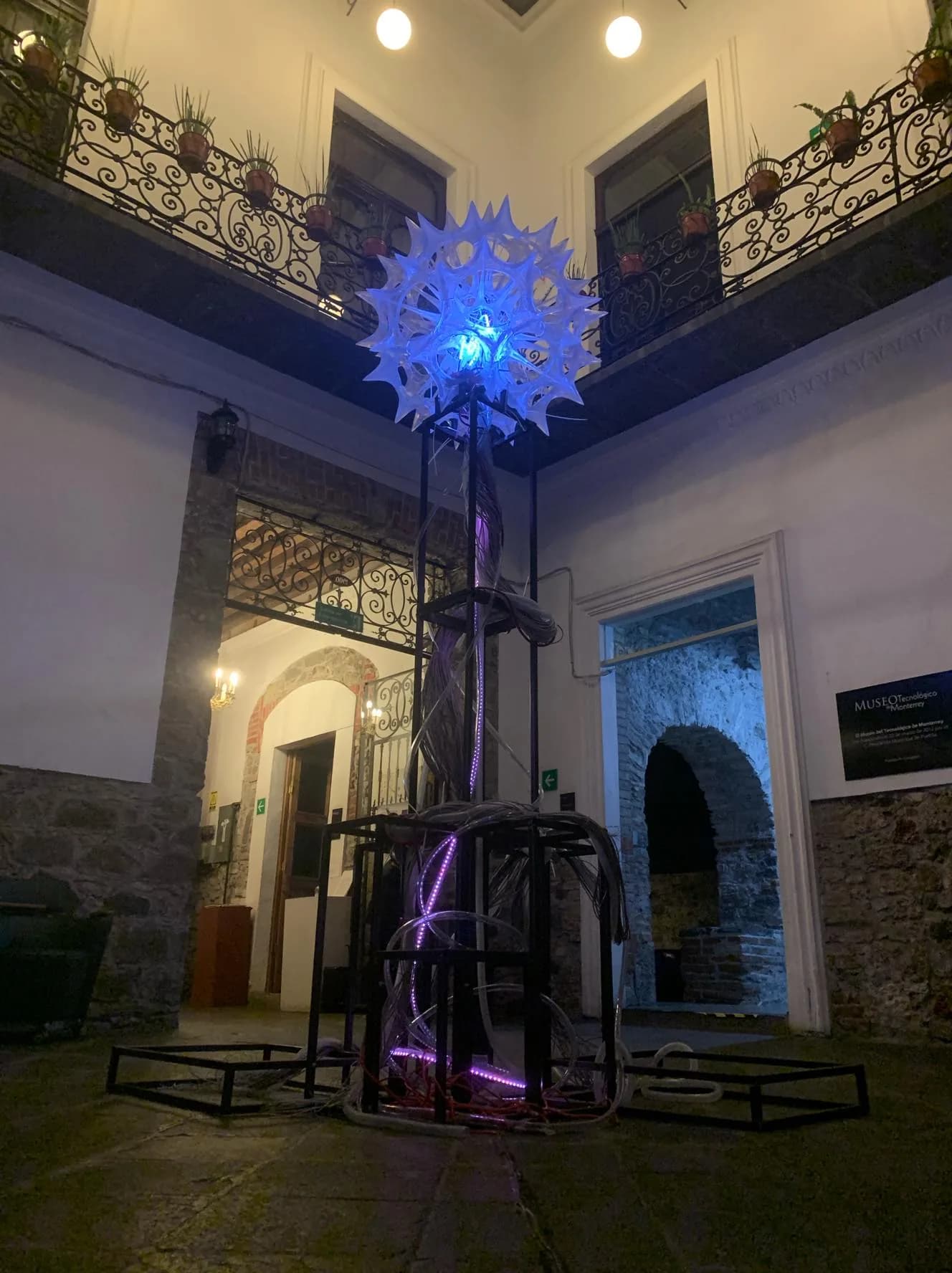 Instalación luminosa azul y violeta Kingdom: The Arrival suspendida en el atrio del Museo Tec